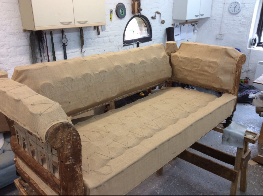 Chesterfield sofa stripped back to hessian during restoration in the workshop